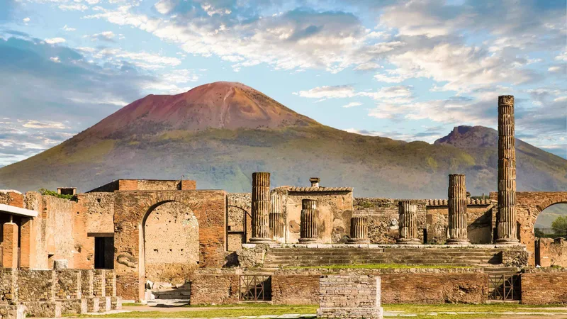 The Forum of Pompeii with Vesuvius behind it under evening cloud, the first stop on Pompeii tours from Rome by coach, Campania, Italy
