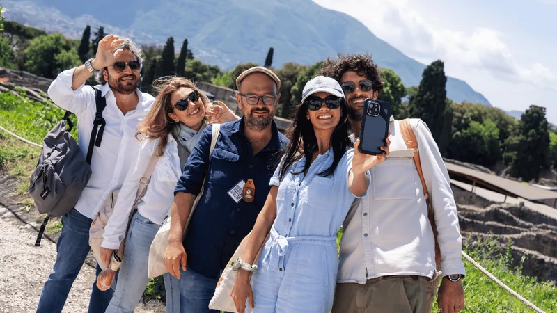 Group of five smiling in front of the ruins with Vesuvius behind on Pompeii tours from Rome by train that pair Pompeii with Herculaneum, Italy